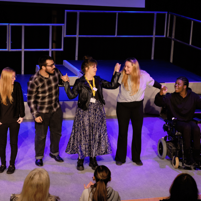 Group of young people with director Jen Davis taking a bow after a performance