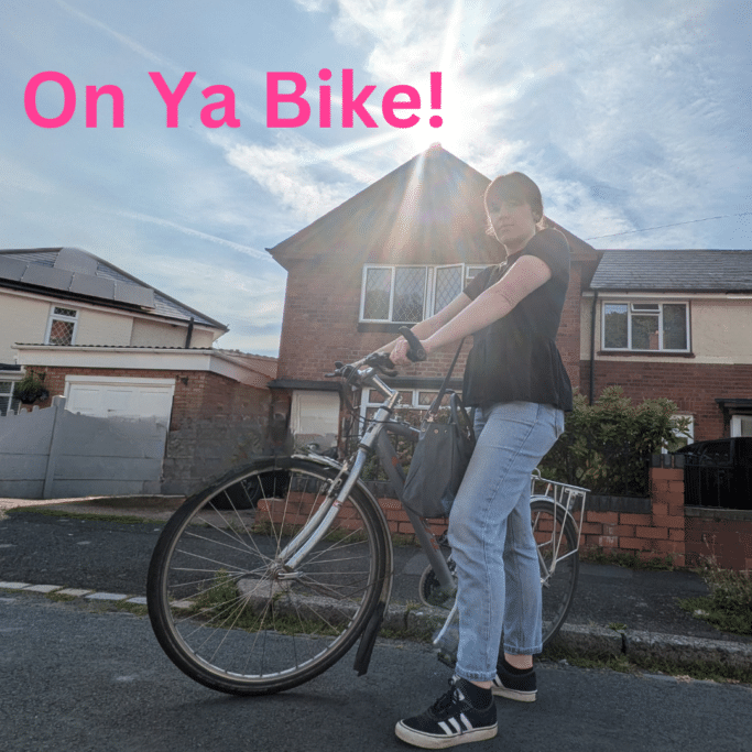 A woman stood outside a house holding a bike texts reads On Ya Bike